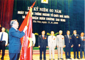 Thủ tướng Phan Văn Khải gắn Huân chương Sao vàng lên lá cờ truyền thống của ngành Tổ chức nhà nước nhân dịp kỷ niệm 60 năm Ngày truyền thống ngành Tổ chức nhà nước (28/8/1945 - 28/8/2005). Ảnh: TTXVN